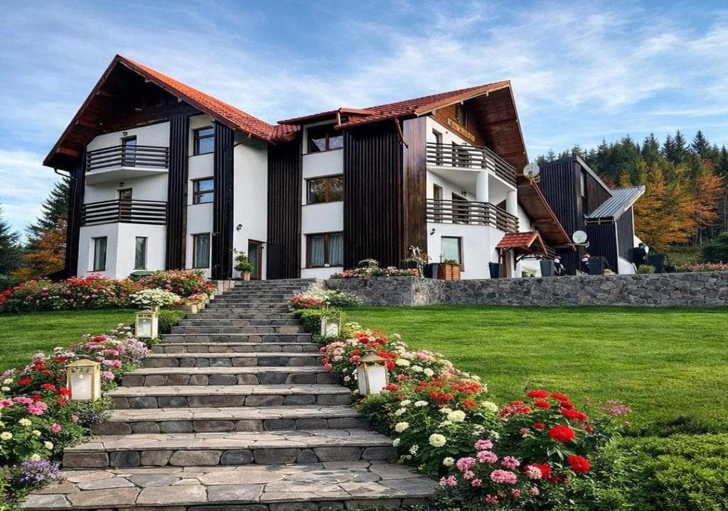 Casa Vânătorului vara, cu scările și florile